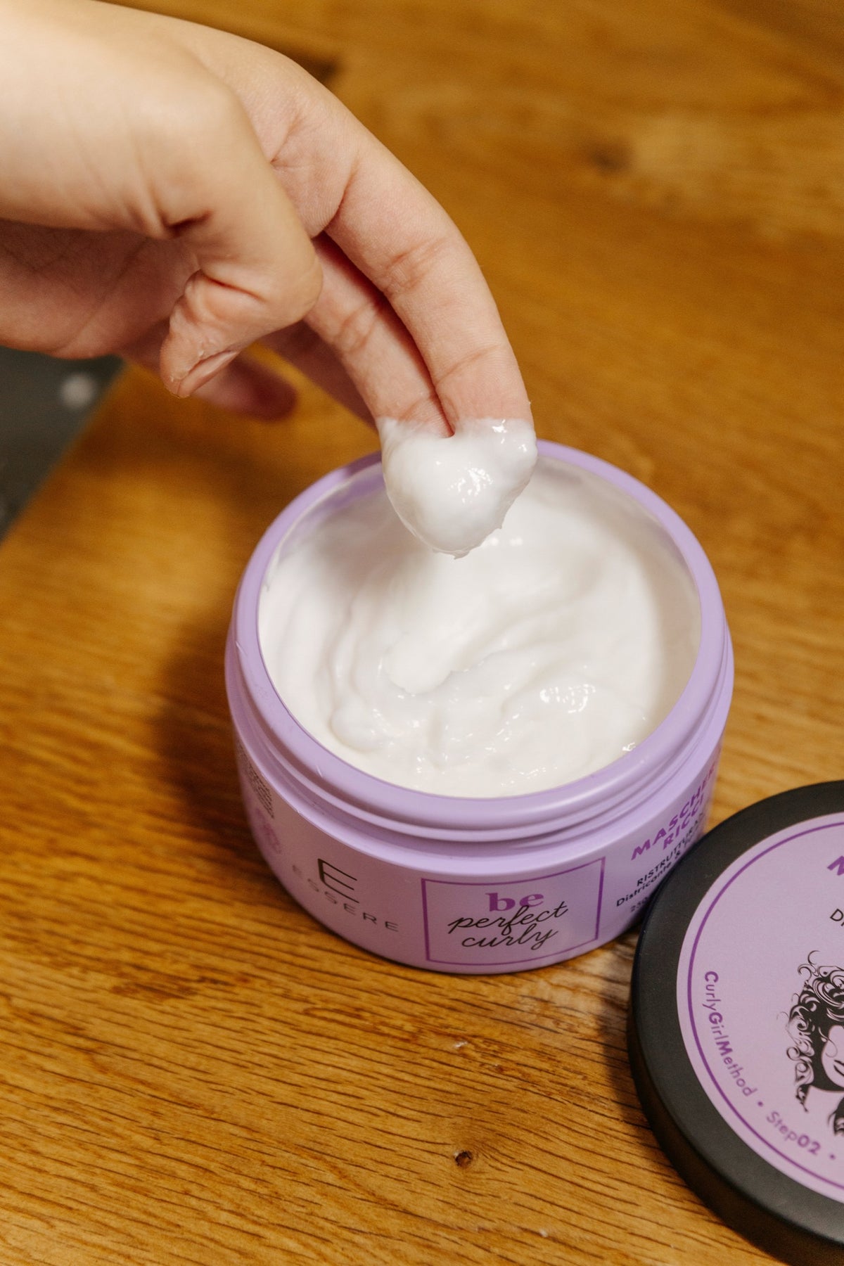 White creamy texture of the Essere Bio Repairing Curly Hair Mask, scooped from the open jar