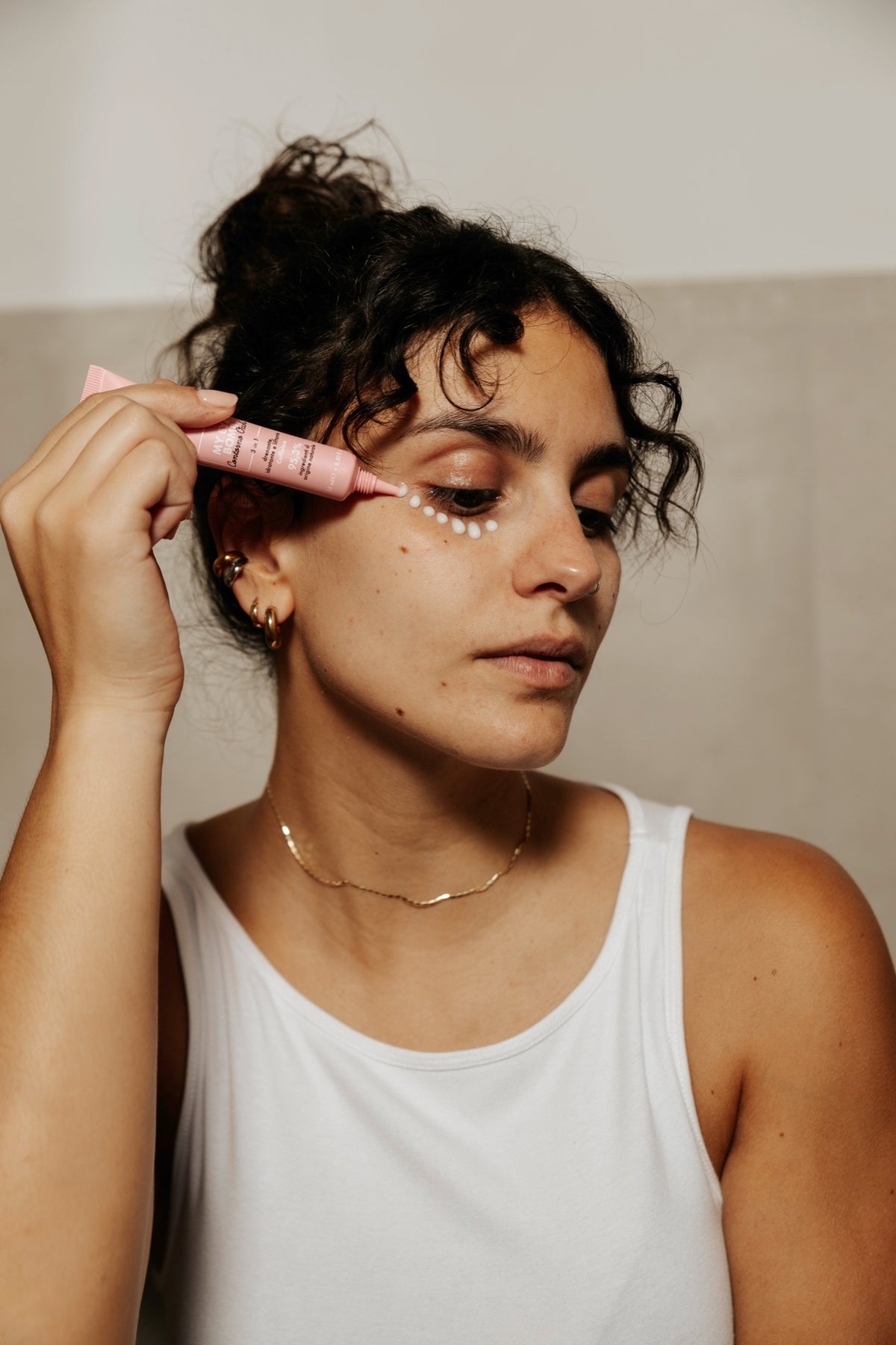 Woman applying Essere Bio My Eye Bomb eye contour to the eye area with the applicator