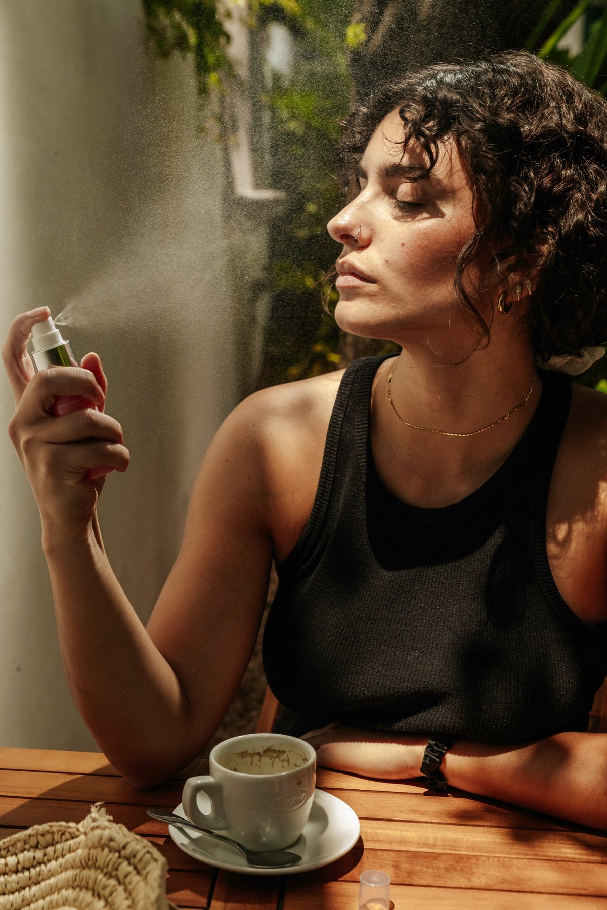 Woman spraying Essere Bio My Holy Water face mist onto her face