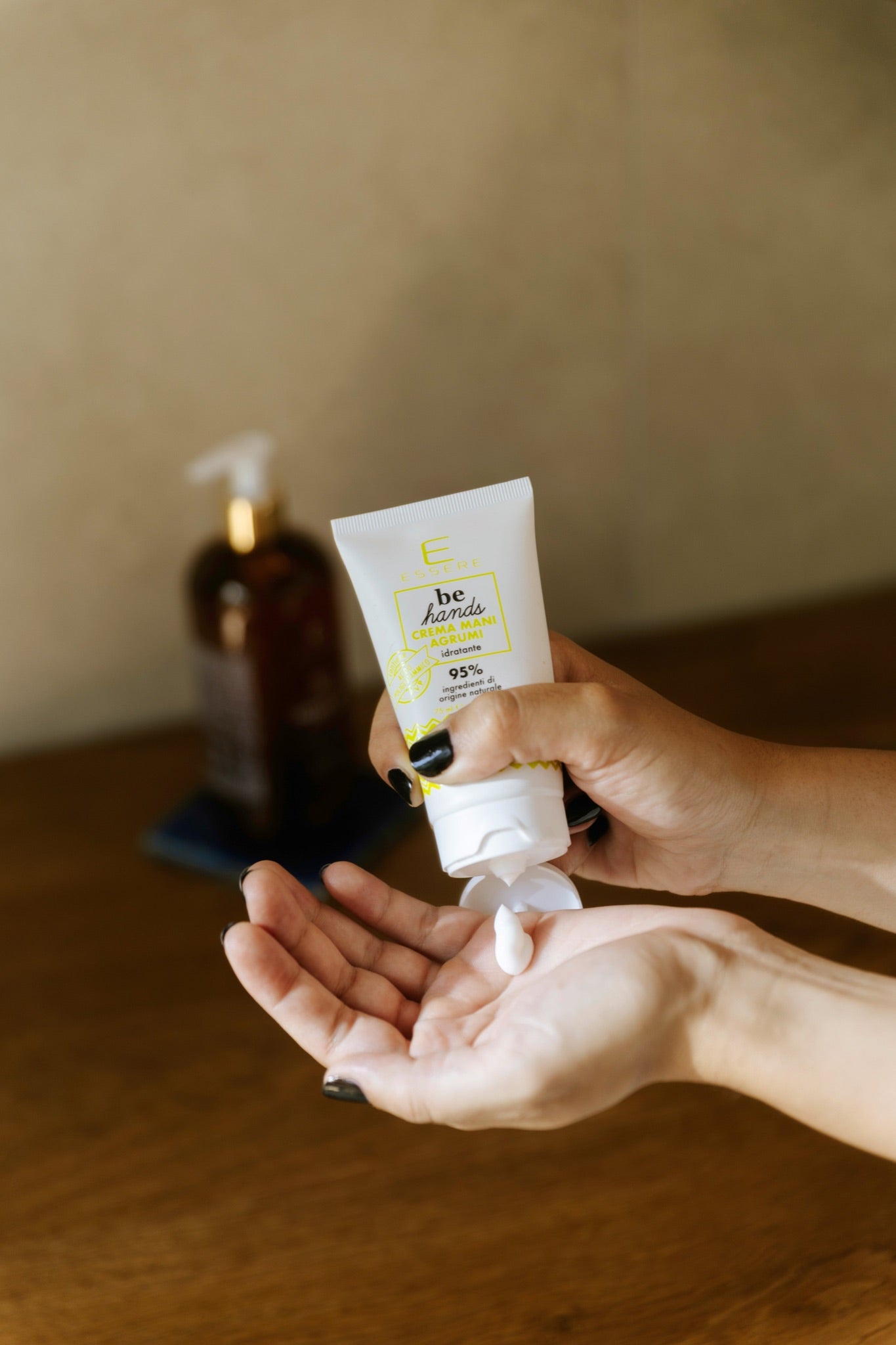 Crema Mani Agrumi Essere Bio dosata sul palmo delle mani, texture idratante della linea Be Hands in uso