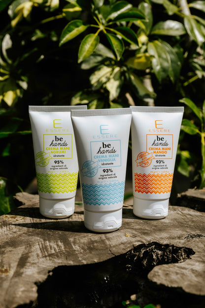 Le tre Creme Mani Be Hands Essere Bio, mango agrumi e vaniglia, in tubo su un tronco tra la vegetazione