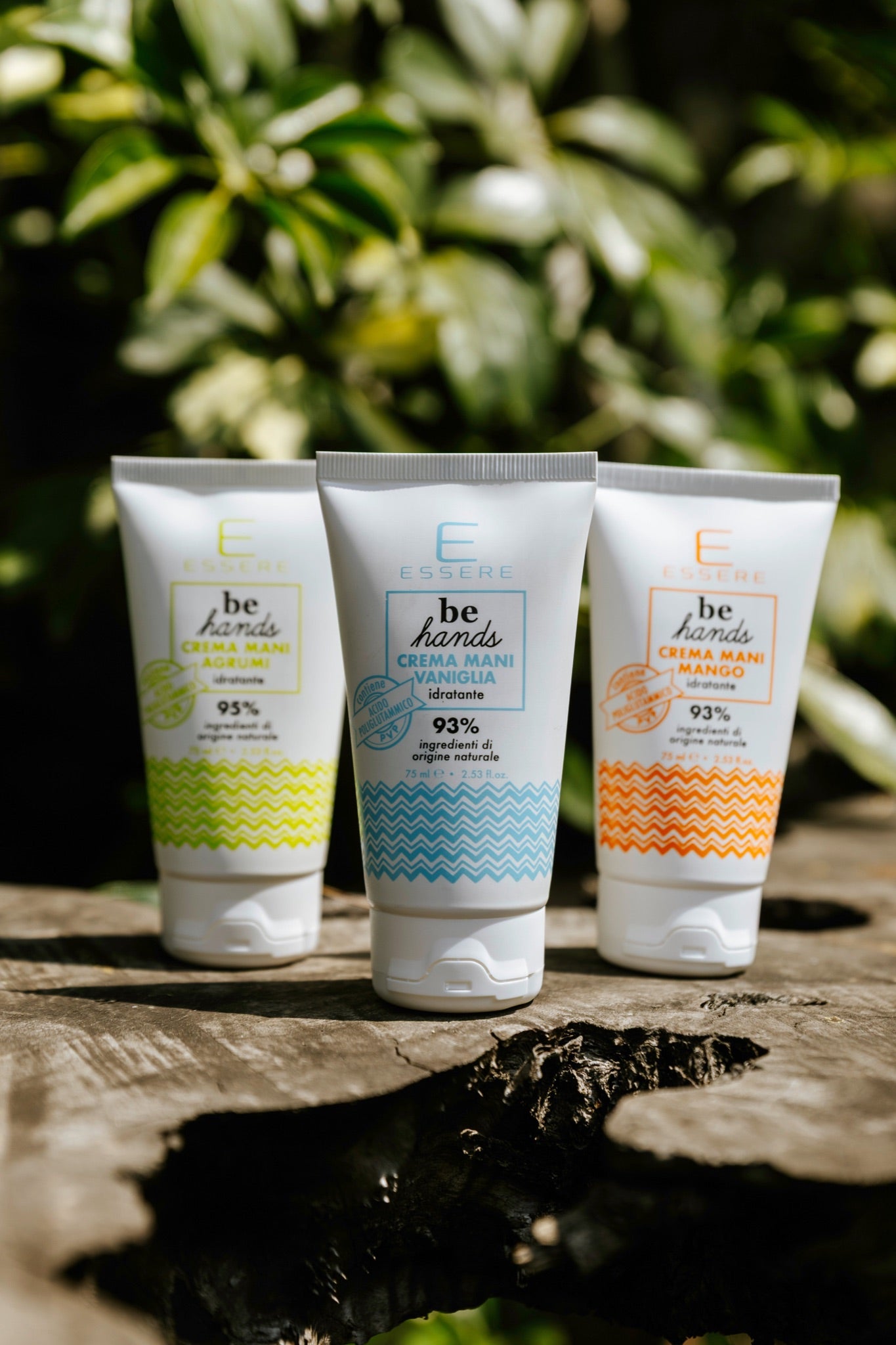 Le tre Creme Mani Be Hands Essere Bio, vaniglia agrumi e mango, in tubo su un tronco tra la vegetazione