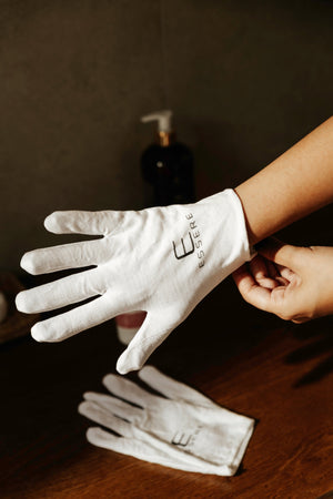 Essere Bio Be Hands Cotton Gloves worn on the hands while a nourishing hand mask sets