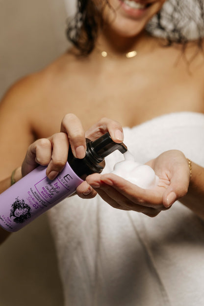Mousse Ricci Nutriente Essere Bio erogata sul palmo della mano, schiuma per lo styling dei ricci