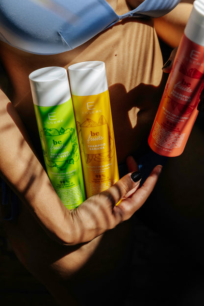 I tre Shampoo Be Fruit Essere Bio, banana mela verde e pompelmo, tenuti in mano in flaconi colorati